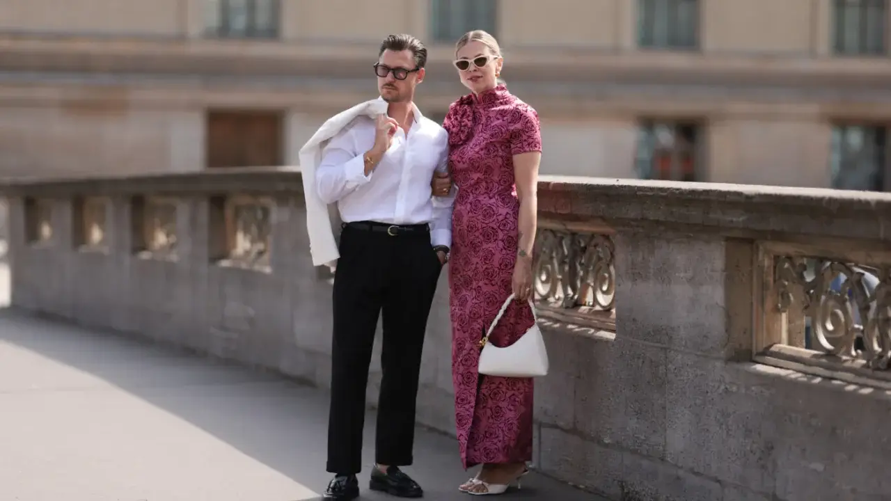 Elegancka para, inspiracja, jak się ubrać do teatru. On w białej koszuli i czarnych spodniach, ona w różowej sukni z kwiatowym wzorem.